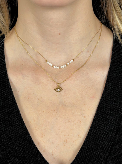 Golden steel pearl necklace with eye and zirconia